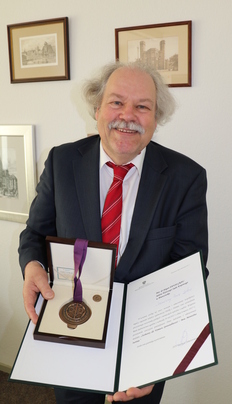 Dr. Jürgen Pansegrau mit Verdiensturkunde und -medaille